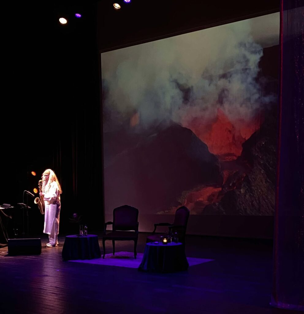 Foto av Kristin Sevaldsen ved siden av video av en vulkan